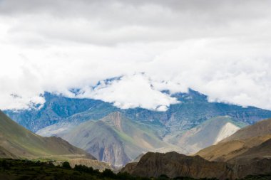 Muktinath, Mustang, Nepal 'deki Sisli Dağlar ve Uzak Evlerle Karanlık Dramatik Çöl Manzarası
