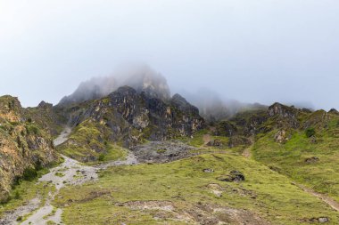 Muktinath, Mustang, Nepal 'deki Sisli Dağlar ve Uzak Evlerle Karanlık Dramatik Çöl Manzarası
