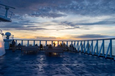 Atlantik Okyanusu, İzlanda - 11 Ağustos 2022: Güzel Portakal Günbatımının tadını çıkaran turistler, Atlantik Okyanusu 'nda Danimarka ile İzlanda arasındaki bir feribottan görüldü.