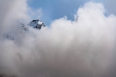 Kanchenjunga bölgesindeki Nepal 'in yüksek Himalayalarında kara bulutlarla kaplı karlı bir dağ tepesi.