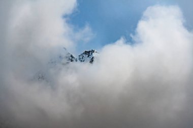 Kanchenjunga bölgesindeki Nepal 'in yüksek Himalayalarında kara bulutlarla kaplı karlı bir dağ tepesi.