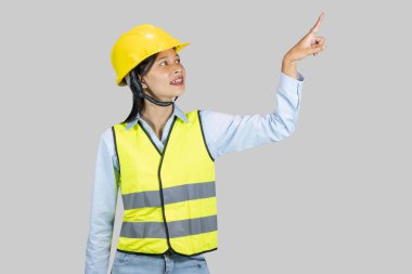 Asyalı kadın inşaat işçisi ve mühendisi mutluluk ve heyecan ifadeleri ve jestleri yapıyor.