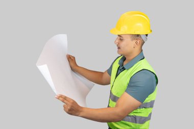 Asyalı Mutlu İnşaat Mühendisi, karton kağıt ve defterle ifade jestleri yapıyor.