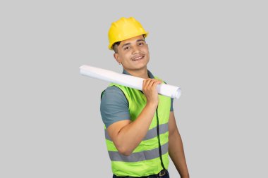 Asyalı Mutlu İnşaat Mühendisi, karton kağıt ve defterle ifade jestleri yapıyor.