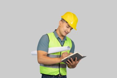 Asyalı Mutlu İnşaat Mühendisi, karton kağıt ve defterle ifade jestleri yapıyor.