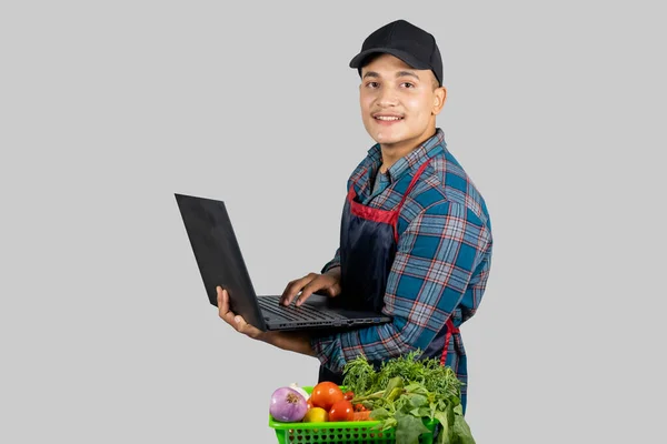 Genç Girişimci Asyalı Sebze Çiftçisi dijital teknoloji bilgisayarı ve cep telefonu kullanıyor 