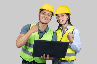 Asyalı Çift Mühendisi & Mimar, inşaat alanında dizüstü bilgisayarla hareketler ve ifadeler yapıyor