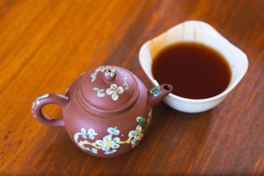 Çok eski bir Çin Çaydanlığı ve çay küçük bir kaseye dökülüyor Çay tatma seremonisi korunmuş siyah çay