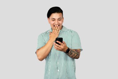 Mobil teknolojiyi kullanan genç Enerji İşçisi jestler ve ifadeler yapıyor. Şaşırtıcı.