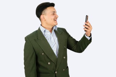 Resmi giyinmiş bir iş adamı, kendine güveni tam, el kol hareketleri ve yüz ifadeleri yapıyor.