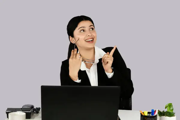 Dizüstü bilgisayarı, kulaklığı ve günlüğü olan Asya kökenli güzel resepsiyonist müşteri hizmetleri çağrı merkezinde jestler ve ifadeler yapıyor.