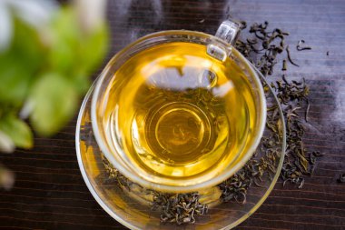 Yasemin çiçekli organik yeşil çay ve çay fincanında kurumuş yapraklı yasemin çayı.