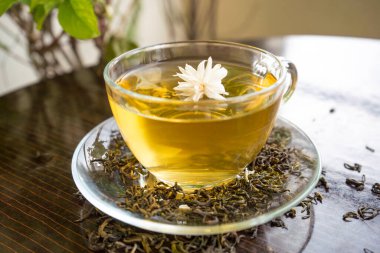 Yasemin çiçekli organik yeşil çay ve çay fincanında kurumuş yapraklı yasemin çayı.
