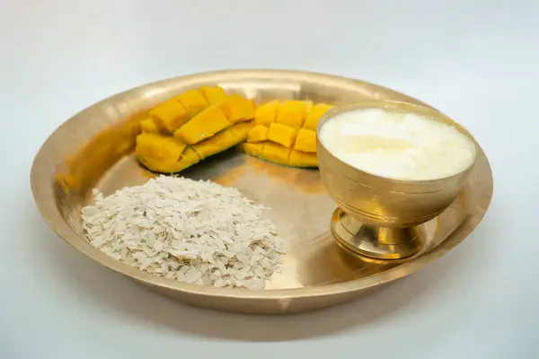 stock image A copper plate and bowl of Dahi Chiura aka Yoghurt and Rice Flakes for Paddy Plantation Celebration Asaar 15 Dahi Chiura Day in Nepal with mangoes