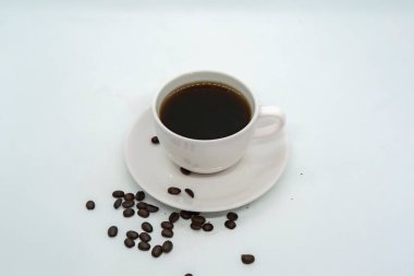 Espresso Americano seramik fantezi bir fincanda taze kahve çekirdeği dağınık beyaz arka plan