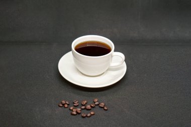 Espresso Americano seramik fantezi bir fincanda taze kahve çekirdeği dağınık beyaz arka plan