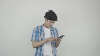 Notepad, cep telefonu ve kulaklıklı genç Asyalı öğrenci müzikten hoşlanan ifadeler veriyor. Stajyerlik Ham Görüntüsü