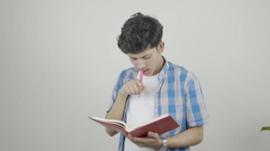 Notepad, cep telefonu ve kulaklıklı genç Asyalı öğrenci müzikten hoşlanan ifadeler veriyor. Stajyerlik Ham Görüntüsü