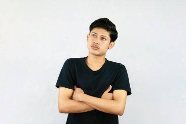 Siyah tişörtlü genç Asyalı erkek bulucuyla ifade ve jestler yapıyor.