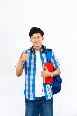 Çanta, Kitap ve kulaklıkla Yurtdışında Genç Erkek Çalışması İfade ve jestler sunar