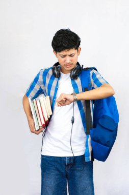 Çanta, Kitap ve kulaklıkla Yurtdışında Genç Erkek Çalışması İfade ve jestler sunar