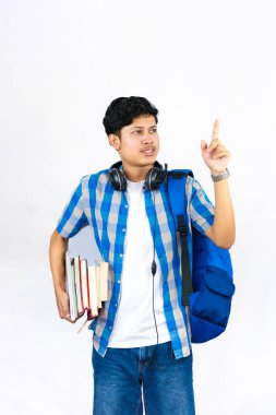 Çanta, Kitap ve kulaklıkla Yurtdışında Genç Erkek Çalışması İfade ve jestler sunar