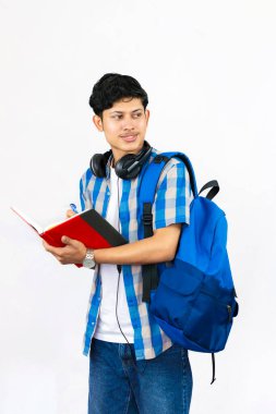 Çanta, Kitap ve kulaklıkla Yurtdışında Genç Erkek Çalışması İfade ve jestler sunar