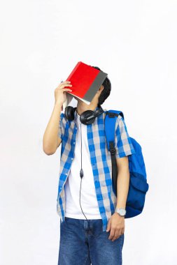 Çanta, Kitap ve kulaklıkla Yurtdışında Genç Erkek Çalışması İfade ve jestler sunar