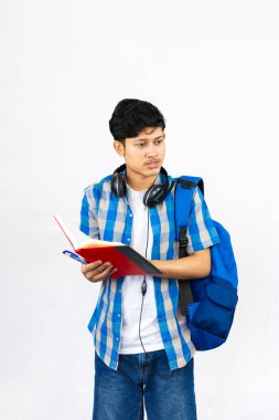 Çanta, Kitap ve kulaklıkla Yurtdışında Genç Erkek Çalışması İfade ve jestler sunar