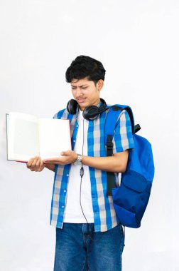 Çanta, Kitap ve kulaklıkla Yurtdışında Genç Erkek Çalışması İfade ve jestler sunar