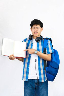 Çanta, Kitap ve kulaklıkla Yurtdışında Genç Erkek Çalışması İfade ve jestler sunar