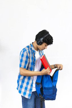 Çanta, Kitap ve kulaklıkla Yurtdışında Genç Erkek Çalışması İfade ve jestler sunar