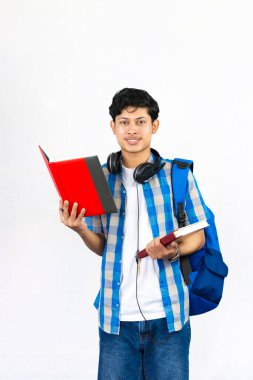 Çanta, Kitap ve kulaklıkla Yurtdışında Genç Erkek Çalışması İfade ve jestler sunar