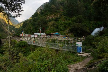 Syafrubesi, Rasuwa, Nepal - 13 Ekim 2024: Langtang Valley Trek 'teki Syafrubesi yolu üzerinde Shops asma köprüsü ve bir çay evinin önündeki şelaleler 