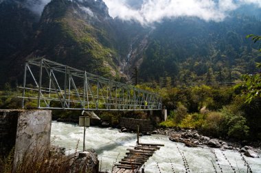 Langtang Village, Nepal - 15 Ekim 2024: Langang Nehri & Köprüsü ile birlikte Ghoda Tabela bölgesindeki Langtang Circuit of Himalayaları 'nın izlerini takip etmek
