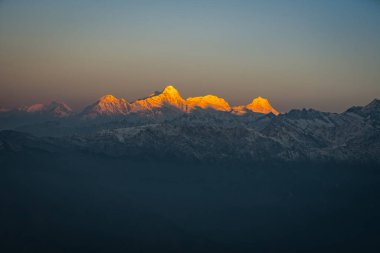 Nepal 'in Langtang Ulusal Parkı' ndaki Himalayalar 'ın karlı dağlık tepelerinde Altın Gün Doğumu