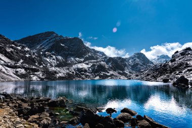 Canlı Gosaikunda mavi-yeşil dağ buzulları, güneş ışığı ve Nepal 'de karlı Himalaya zirveleri