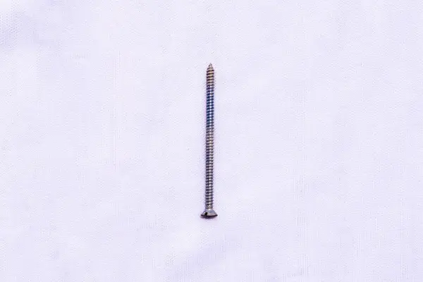 Tek bir gümüş metal çivi çivi beyaz arka planda izole edilmiş inşaat için gerekli donanım