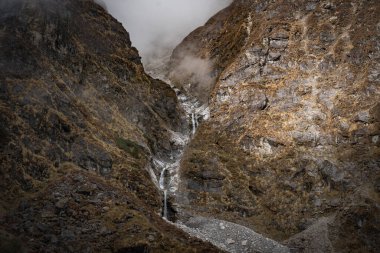 Nepal 'in Langtang bölgesinde bir köprüsü olan dağlardaki güzel Himalaya Buzul Şelaleleri.