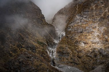 Nepal 'in Langtang bölgesinde bir köprüsü olan dağlardaki güzel Himalaya Buzul Şelaleleri.