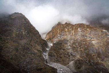 Nepal 'in Langtang bölgesinde bir köprüsü olan dağlardaki güzel Himalaya Buzul Şelaleleri.