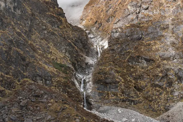 Nepal 'in Langtang bölgesinde bir köprüsü olan dağlardaki güzel Himalaya Buzul Şelaleleri.