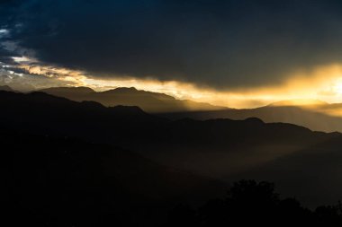 Kutumsang, Helambu, Nuwakot 'taki Nepal dağlarında bulutlarla birlikte sabahın erken saatlerinde altın gün doğumu