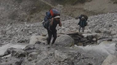 Langtang Village, Nepal - 25 Ekim 2024: Nepal Himalayaları 'nın Langtang Köyü Bölgesi' nde ağır yük ve çantalar taşıyan Porter