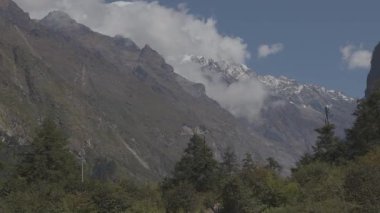 Langtang Village, Nepal - 25 Ekim 2024: Langtang Dağları 'nın Bulutları ve Nepal' in Himalayaları 'nda yürüyüş yapan Trekkerleri ile Zaman Çizelgesi