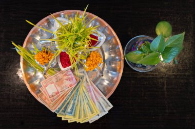 Tika ve Jamara, Nepal 'deki Dashain festivali sırasında Vijaya Dashami töreni için arpa filizi, para ve meyve içeren gümüş bir kaba koydular..