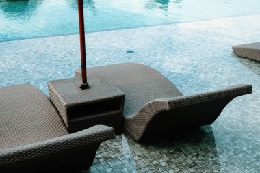 Tropikal tatil beldesindeki havuzda şezlong görüntüsü