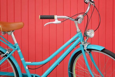 Kırmızı ahşap arka planda mavi renkli bisiklet, bisikleti kapat.