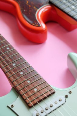 Fotokopi alanı olan pembe bir zemin üzerinde elektro gitar ve bas gitar.