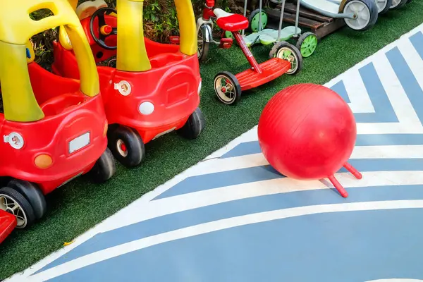 赤いおもちゃ車とボールで活気に満ちた遊び場のシーンのトップビュー — ストック写真